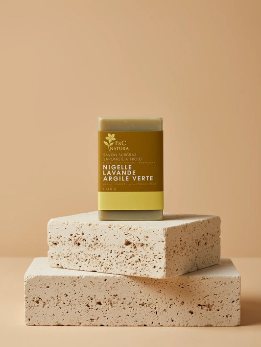 Savon artisanal F&C Natura à la nigelle, lavande et argile verte, pour peaux sensibles et mixtes. Saponifié à froid au Maroc, naturel et biodégradable, hydrate, purifie et apaise la peau en douceur.